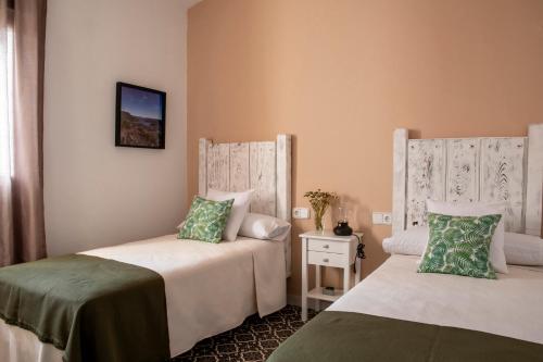 a bedroom with two beds and a nightstand with at Apartamentos Rurales Helechosa, Las Tres Peñas in Helechosa