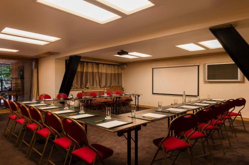 a conference room with a long table and red chairs at Hôtel Macchi Restaurant & Spa in Châtel