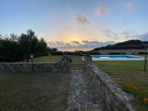a stone retaining wall with a gate and a pool at Abba Urci in Tertenìa