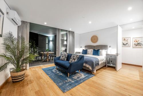a bedroom with a bed and a chair and a table at 17 Marine - 3Bedroom Sea-Facing Apt101 in Hermanus