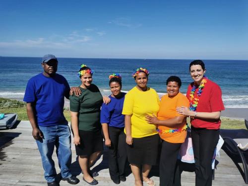 a group of people posing for a picture at the beach at African Oceans Manor on the Beach in Mossel Bay