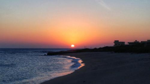 a sunset over a beach with the ocean at Yu B&B in Wang-an