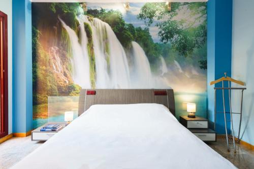 シウダー・レアルにあるHostal Frasca by Vivere Staysの大きな滝の壁画が壁に施されたベッドルーム