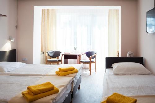 a hotel room with two beds with yellow towels on them at Graal SPA in Świnoujście