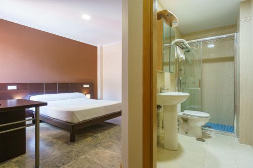 1 dormitorio con 1 cama y baño con lavamanos en Hostal Frasca by Vivere Stays, en Ciudad Real