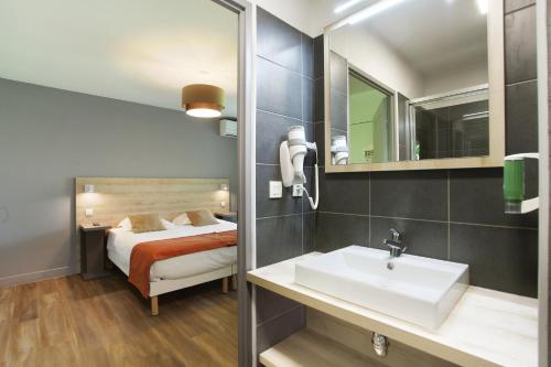 uma casa de banho com um lavatório e uma cama em Odalys City Aix en Provence Le Clos de la Chartreuse em Aix-en-Provence