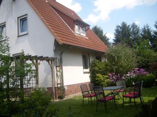 una mesa y sillas frente a una casa en Ferienhof Steinbruch, en Wietzendorf