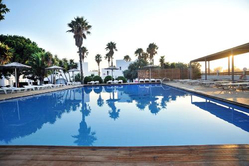 a large swimming pool with chairs and palm trees at Summer Village of Hippokrates - Adults only in Marmari