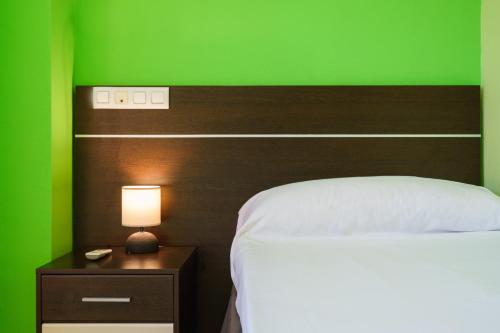 a green bedroom with a bed and a green wall at Hostal Frasca by Vivere Stays in Ciudad Real