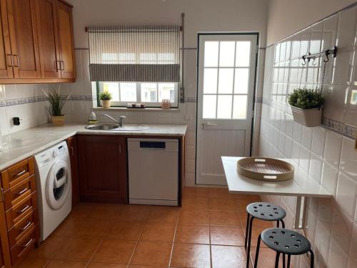 uma cozinha com um lavatório e uma máquina de lavar roupa em Country Town Apartment em Almeirim