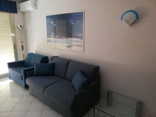 a living room with a blue couch and a picture at Petit avec classe Sanremo in Sanremo