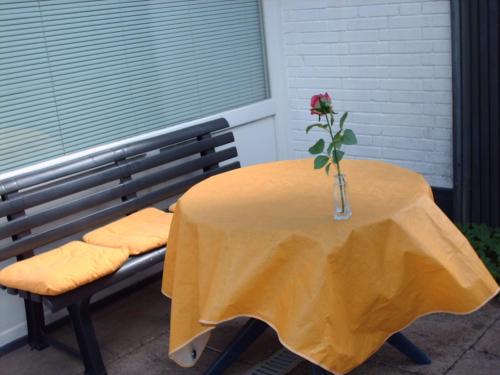 uma mesa com um vaso com uma flor em Sommerheide em Bad Bevensen