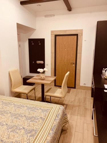 a room with a bed and a table and chairs at WINE & ROSE BOUTIQUE HOTEL in Kharkiv