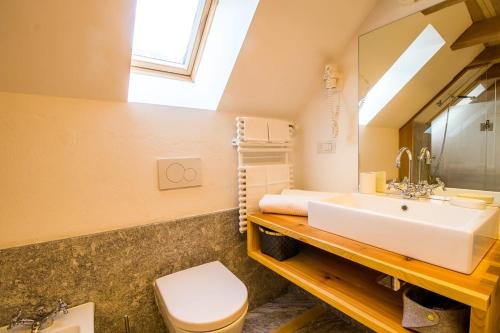 a bathroom with a sink and a toilet and a mirror at Camere Bar Rudi in Santa Maria Maggiore