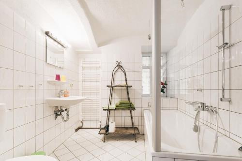 a white bathroom with a shower and a sink at Ferienwohnungen Königstein in Königstein an der Elbe