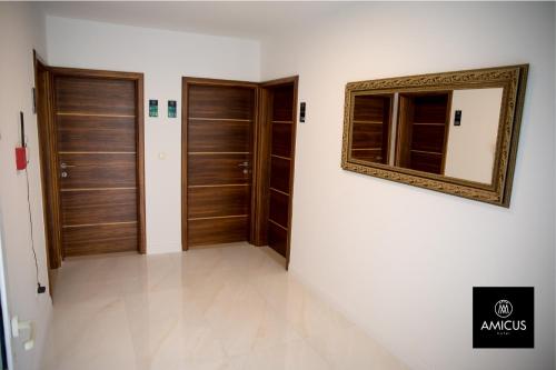 a hallway with wooden doors and a mirror on the wall at Hotel Amicus in Mostar