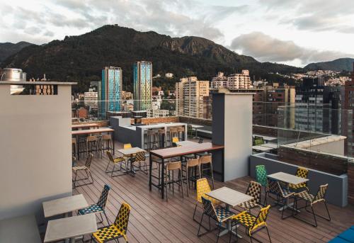 eine Terrasse mit Tischen und Stühlen auf dem Dach in der Unterkunft Spotty Bogotá Centro in Bogotá