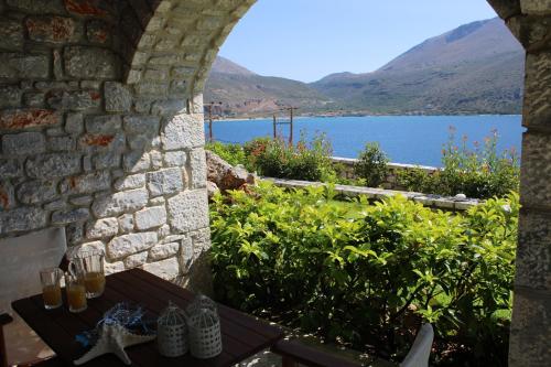 a view of a lake from a stone wall at Εn Plo Luxury Suites in Karavostasion