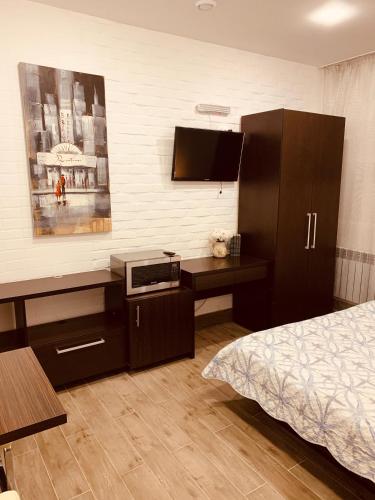 a bedroom with a bed and a desk with a microwave at WINE & ROSE BOUTIQUE HOTEL in Kharkiv