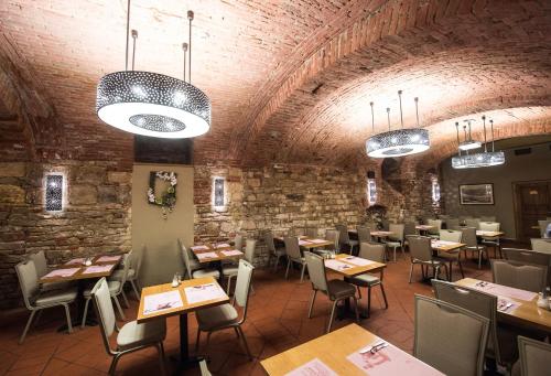a restaurant with tables and chairs and a brick wall at Hotel Rott in Prague