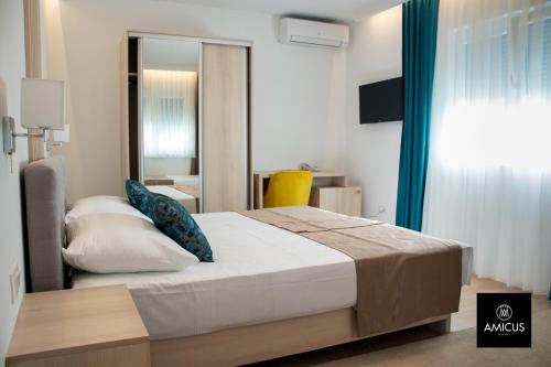 a bedroom with a large bed and a mirror at Hotel Amicus in Mostar