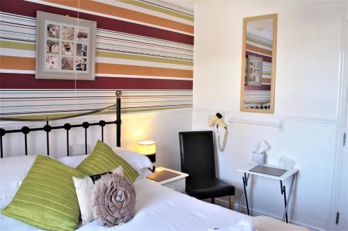 a bedroom with a bed and a chair and a desk at Serena Court Hotel in Skegness