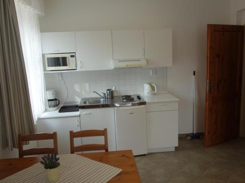 a kitchen with white cabinets and a table with a tableablish at MINERVA in Špindlerův Mlýn