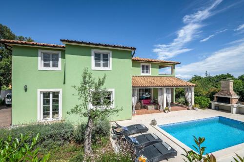 a green house with a swimming pool in front of it at Villa Branca 6+2 in Krnica