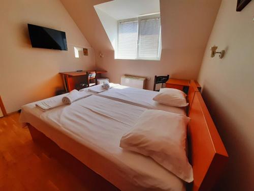 a bedroom with a large bed with white sheets and pillows at Guest House Diel in Veliko Tŭrnovo