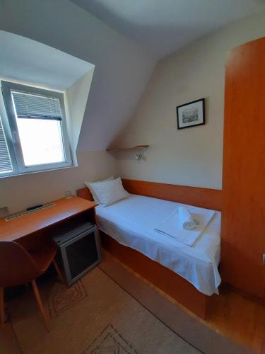 a small bedroom with a bed and a desk at Guest House Diel in Veliko Tŭrnovo