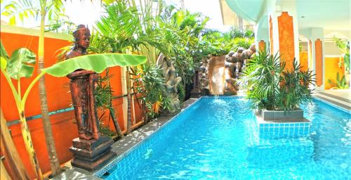 a pool in a hotel with plants and a swimming pool at JOOPLAND Luxury Pool Villa Pattaya Walking Street in Pattaya South
