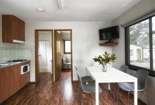 a kitchen and dining room with a white table and chairs at BIG4 Castlemaine Gardens in Castlemaine