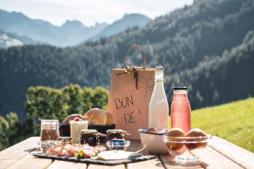 een picknicktafel met een tas en eten erop bij Batacör - Natures Heartbeat in San Vigilio Di Marebbe