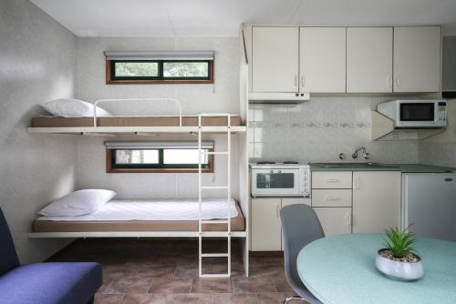 a small room with a bunk bed and a table at BIG4 Castlemaine Gardens in Castlemaine