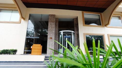 a house with glass doors and green plants at The Fern Residency Sarnath in Varanasi