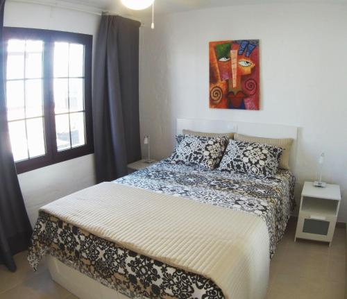 ein Schlafzimmer mit einem Bett und einem Wandgemälde in der Unterkunft Castillo Sol Bungalow in Caleta de Fuste