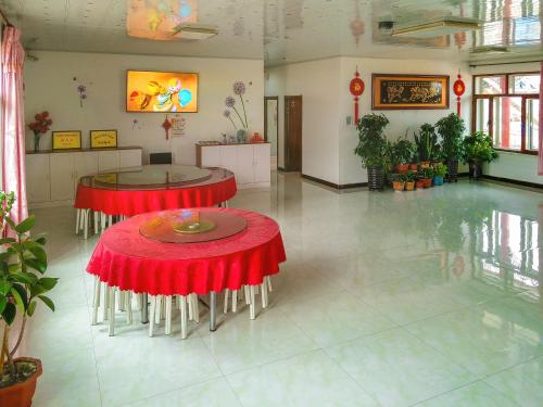 een kamer met twee tafels met rode tafellakens bij Rime Island Manzhaosongju Inn in Jilin