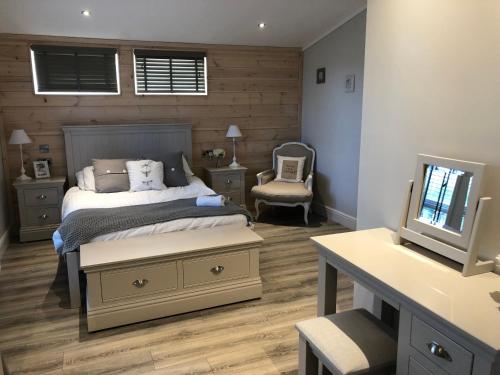 a bedroom with a bed and a desk and a television at 7 The Oaks in North Walsham