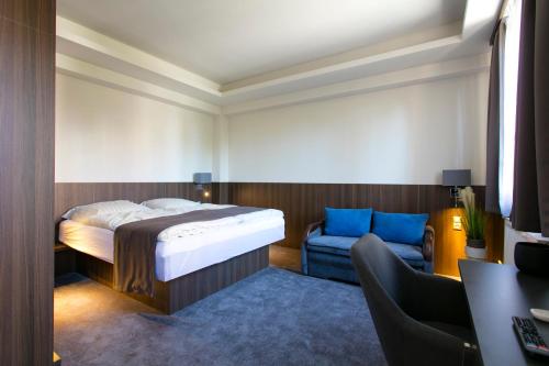a bedroom with a bed and a couch at New York Pension in Dunajská Streda