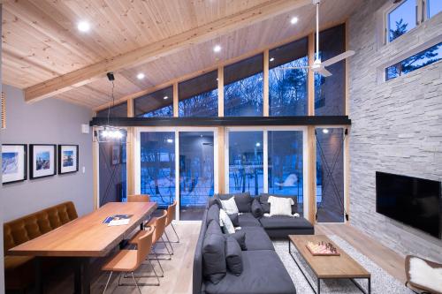 a living room with a couch and a table at Cherrywoods Place by Hakuba White Fox Company in Hakuba