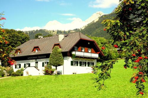 a large house in a field of green grass at Gästehaus Prugger by Schladmingurlaub in Ramsau am Dachstein