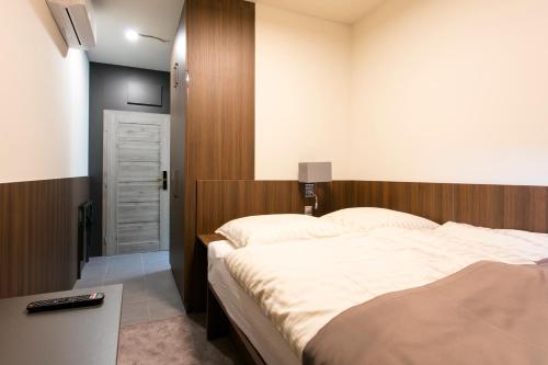 a bedroom with a large bed with a wooden headboard at New York Pension in Dunajská Streda