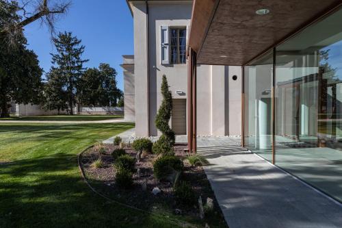 a house with glass doors and a yard at Villa Cantoni Marca in Sabbioneta