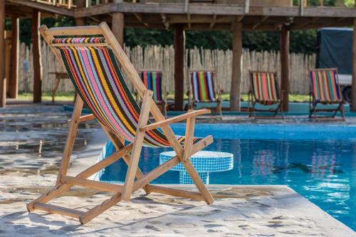 a wooden chair sitting next to a swimming pool at Ruamoko Hostel in Rivas
