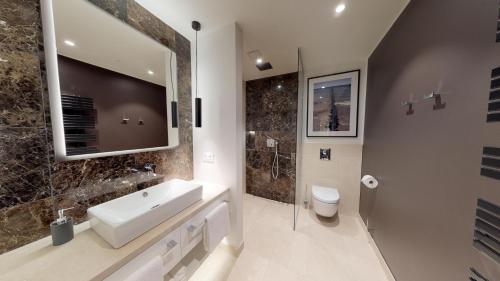 a bathroom with a sink and a toilet and a mirror at White Pearl Apartment 3.06 in Timmendorfer Strand