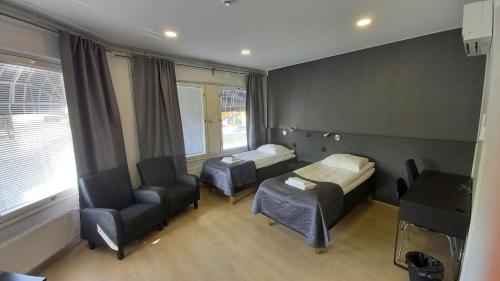 una habitación de hospital con 2 camas y una silla en Hotelli Marilyn, en Harjavalta