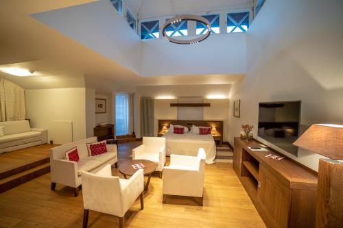 Hotel Pacsirta في سوفاتا: غرفة معيشة كبيرة مع سرير وأريكة