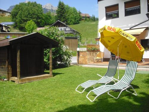 two chairs and an umbrella in a yard at Pension Leitner in Hofen