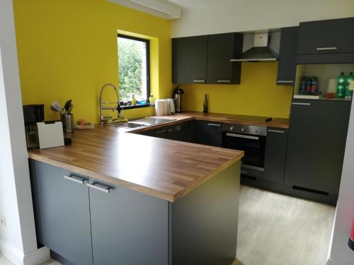 a kitchen with black cabinets and a wooden counter top at DURBUY-COSY Appartement 2 in Durbuy
