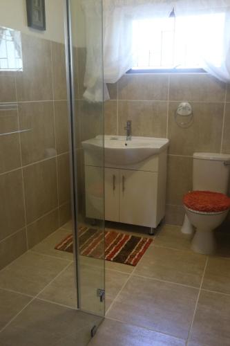 La salle de bains est pourvue d'un lavabo et de toilettes. dans l'établissement Brenton Lake Holiday Cottages, à Brenton-on-Sea